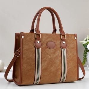 Brown faux leather tote bag with tricolor striped webbing and adjustable shoulder strap