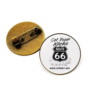 Vue avant et arrière du badge rétro Route 66 montrant la finition bronze et le fermoir épingle