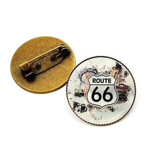 Vue détaillée du pin's Route 66 en verre montrant le dos en alliage bronze et l'épingle