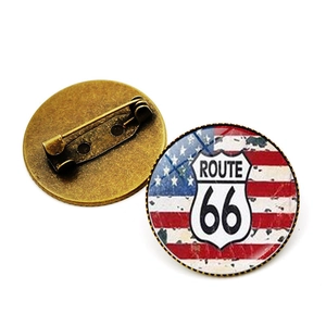 Vue détaillée avant et arrière d'une broche en verre vintage Route 66 avec base bronze