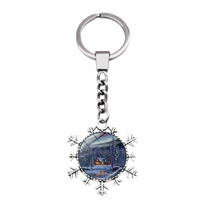 Detail of snowflake keychain featuring a winter cabin art pendant with silver finish