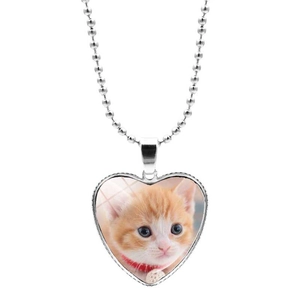 Détail macro du pendentif en forme de cœur avec cabochon chat mignon et chaîne à billes
