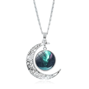 Detail of silver hollow moon pendant featuring northern lights forest scenery on wave chain