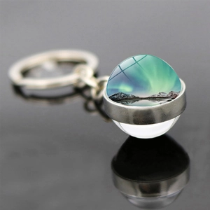 Macro shot of Northern Lights glass ball keychain with brushed metal ring and reflection