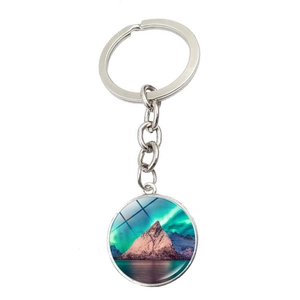 Detail view of round aurora borealis pendant keychain featuring snow mountains and northern lights