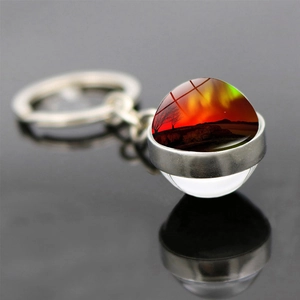 Double-sided glass ball keychain with red sunset landscape and metal keyring reflection
