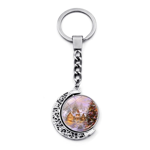 Vue détaillée du porte-clés rotatif croissant de lune avec pendentif maison de Noël