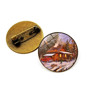 Vue détaillée de la broche en bronze avec décor de maison sous la neige et fermoir