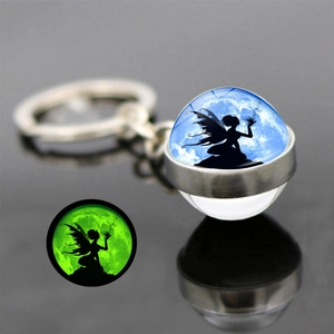 Detailed macro view of glowing fairy glass ball keychain with green luminous effect
