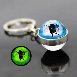 Glow-in-the-dark butterfly fairy keychain showing green luminous effect in dark