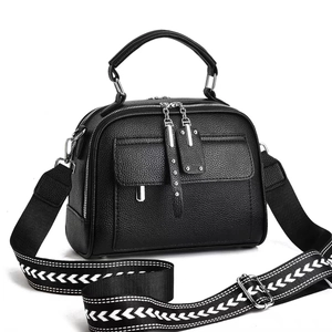 Minimalist black pebble leather square handbag with geometric woven shoulder strap