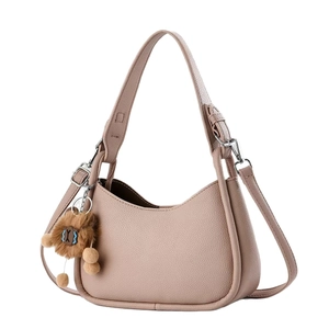 Sac bandoulière rose en cuir grainé avec pendentif ours en peluche sur fond blanc
