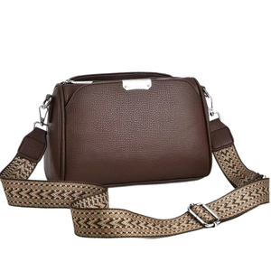Dark brown leather crossbody bag with multicolored geometric woven strap and silver hardware
