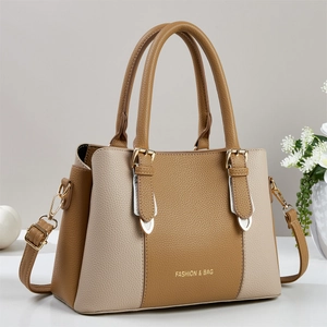 Elegant two-tone leather tote bag with top handles and adjustable shoulder strap