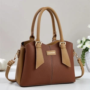 Contrast brown leather handbag with gold metal tag and adjustable shoulder strap