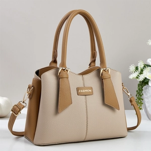 Elegant two-tone faux leather handbag in beige and brown with adjustable gold strap