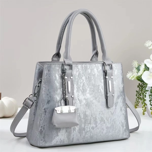 Silver metallic textured handbag with vertical stripes and a small matching bag charm