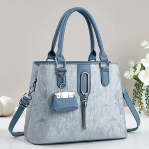 Elegant silver-grey structured handbag with tassel charm and textured vertical patterns