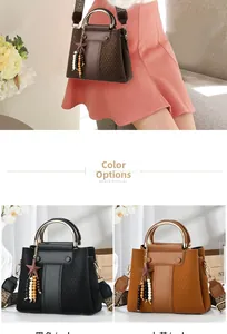 Detail of paneled leather handbag featuring gold ring handles and star charm accessories
