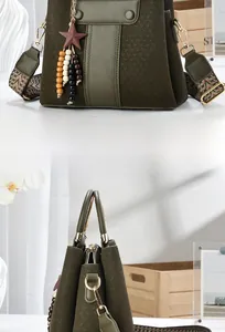 Detail of dark olive textured handbag featuring a star charm and bohemian woven strap