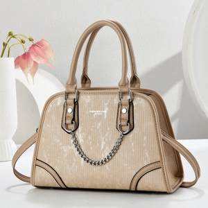 Detail of khaki leather Boston bag with vertical texture and vintage chain decoration