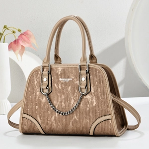 Detail of tan textured Boston bag with silver chain and FASHION & BAGS branding