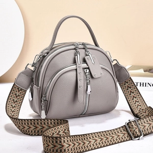 Gray lychee grain leather crossbody bag with multiple zippers and ethnic style strap