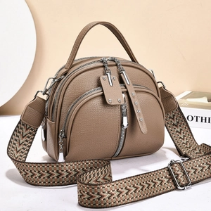 Detail of khaki leather handbag with triple zippers and woven vintage shoulder strap