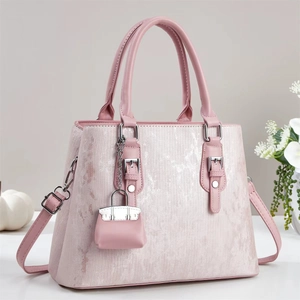 Sac à main rose avec texture perle, bandoulière réglable et mini pendentif décoratif