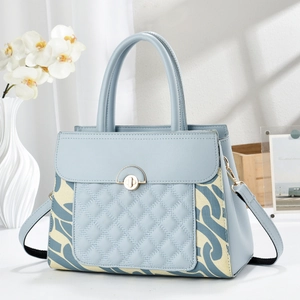 Détail macro d'un sac à main matelassé bleu avec serrure dorée et motifs de fleurs