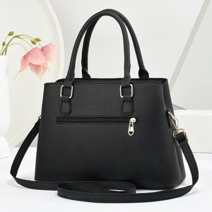 Detail of black lychee leather tote with gold heart zipper and detachable shoulder strap