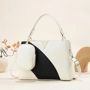 Detail of contrast stitch handbag featuring gold V-shaped hardware and lychee grain texture