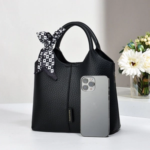 Detail of black pebbled leather bucket bag with decorative heart pattern silk scarf