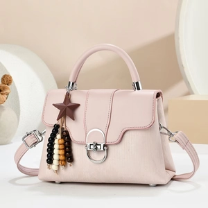 Detail of light pink tote bag featuring a star pendant and multi-color wooden beads