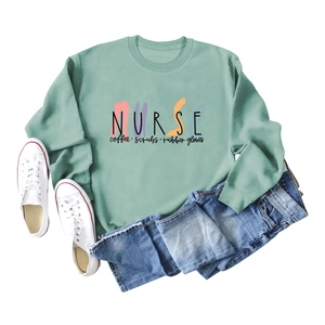 Flat lay of mint green sweatshirt with Nurse Coffee Scrubs print and canvas shoes