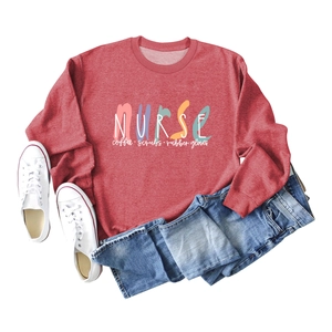 Flat lay of a dark red nurse coffee scrubs sweatshirt with denim jeans and sneakers