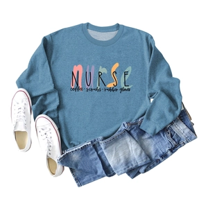 Flat lay of blue Nurse Coffee Scrubs sweatshirt with denim shorts and white sneakers