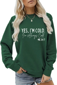 Détail d'un sweat-shirt vert foncé à col rond avec impression du slogan 'YES I'M COLD'