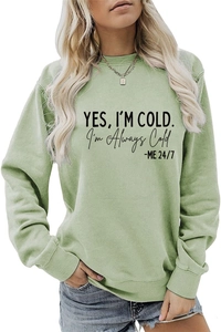 Détail d'un sweat vert clair avec slogan YES I'M COLD et finitions des bords-côtes
