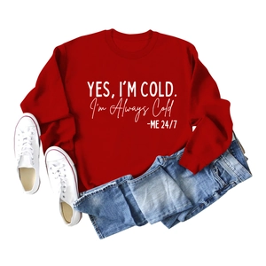 Sweat rouge à col rond avec slogan 'YES I'M COLD' blanc et jean bleu à plat