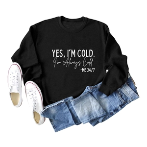 Mise à plat d'un sweat noir avec message, d'un jean bleu et de baskets en toile blanches