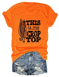 Flat lay of an orange graphic t-shirt with blue distressed denim shorts and corn print