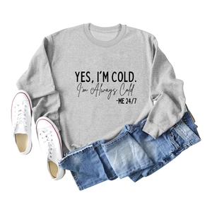 Mise à plat du sweat gris en coton avec imprimé YES I'M COLD et un jean en denim