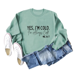 Mise à plat du sweat à col rond vert menthe avec texte, jeans et baskets blanches