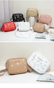 Détails rapprochés de broderies florales sur des sacs bandoulière en cuir de diverses couleurs
