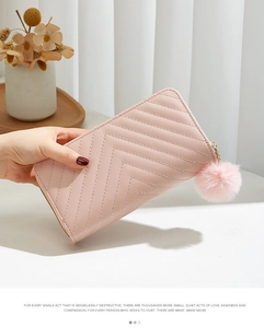 Pink chevron quilted long wallet for women featuring a pompom charm and gold zipper