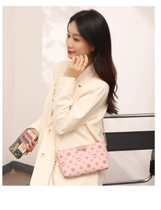 Pink crossbody square bag with circle monogram pattern and gold chain strap on model