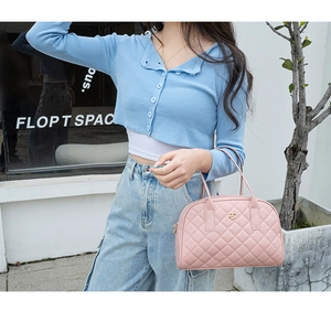 Détail du sac à main rose matelassé avec fermoir fleur dorée et broderie élégante