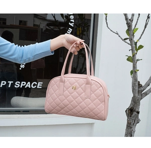 Détail du sac à main rose matelassé en similicuir avec logo fleur doré et anses
