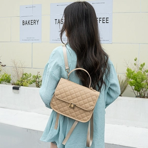 Elegant khaki quilted women's backpack with golden lock shown on a model's back